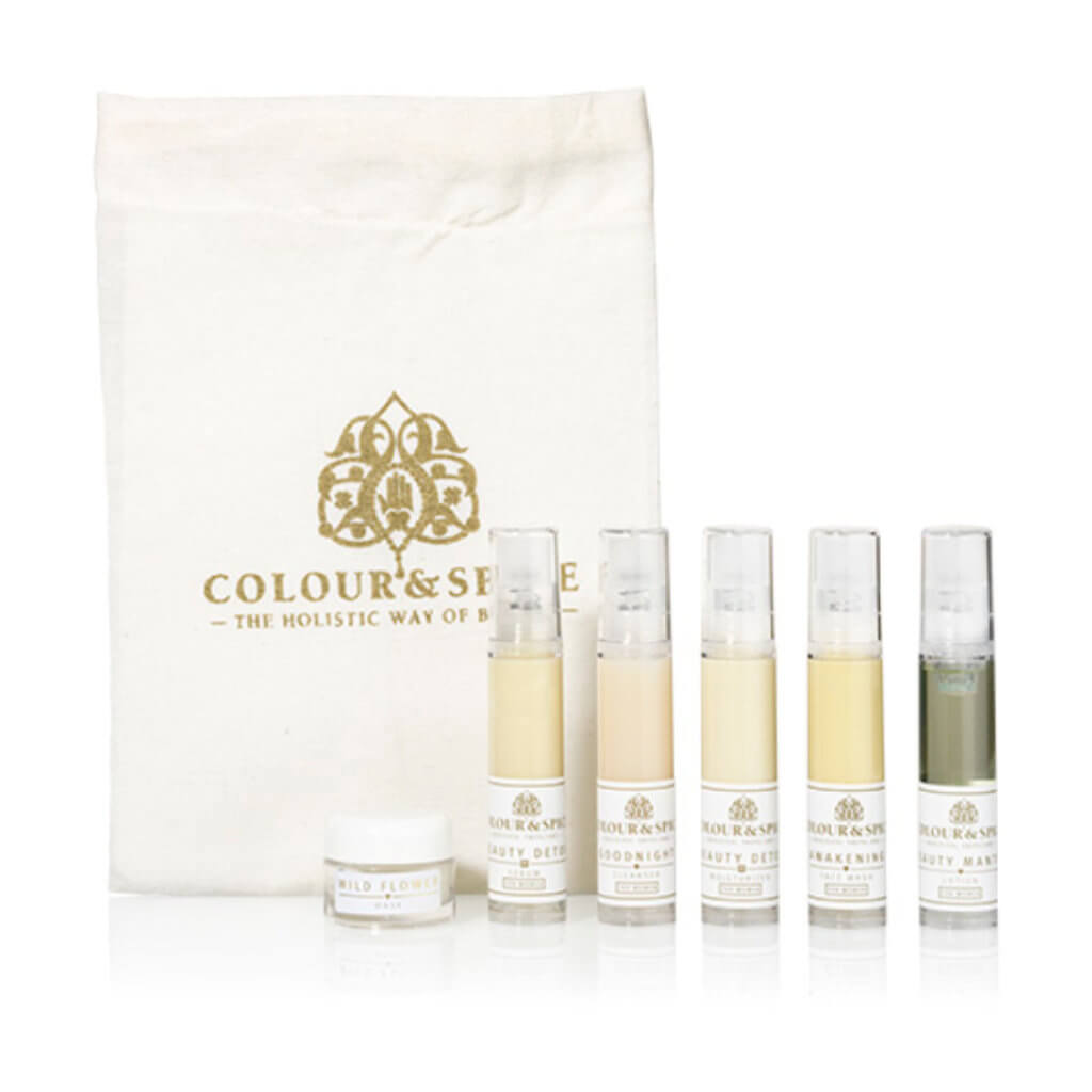 katoenen tasje met logo van holistisch beautymerk colour and spice met travel sized natuurlijk serum, moisturizer, dagcreme, gezichtsreiniger, gezichtsolie en rescue creme, complete miniset  huidverzorging