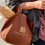 Gevuld bourgondie bruin katoenen tasje met opdruk . sfeer van shoppen op zomerse dag