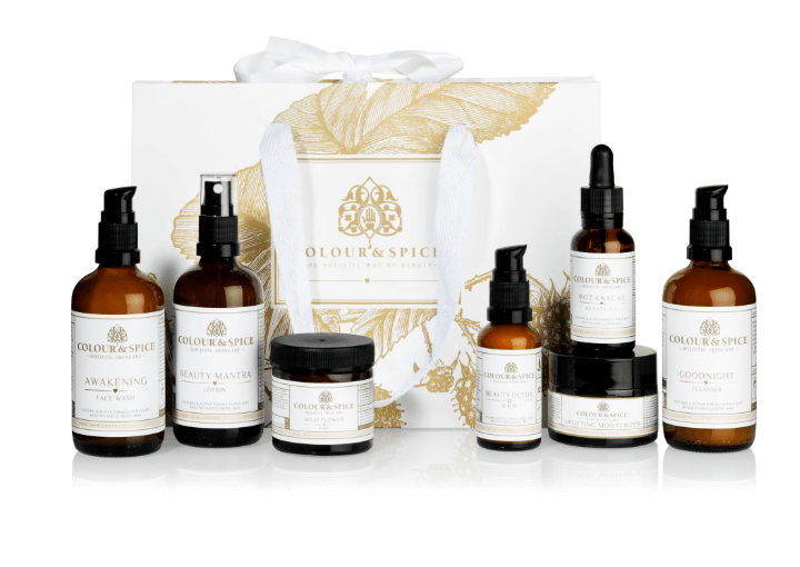 Beauty pakket Natuurlijke huidverzorging van Colour&spice mooi gedecoreerd wit tasje met bruin glazen flesjes en potten serums, moisturizers, cleanser, face wash en masker ervoor 