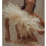 Artistiek beautybeeld van Colour&Spice met veren en huidverzorgingsritueel